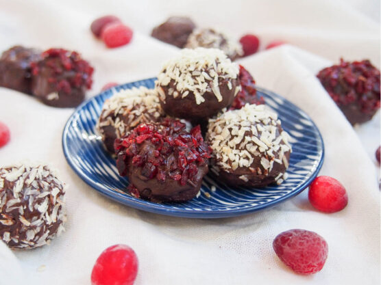 Cranberry truffles topped with chopped cranberries and shredded coconut