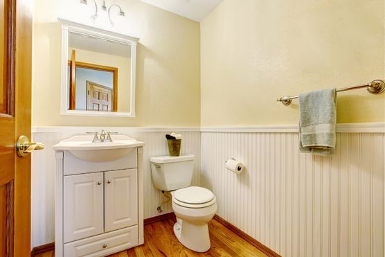white vanity for bathroom with wooden flooring