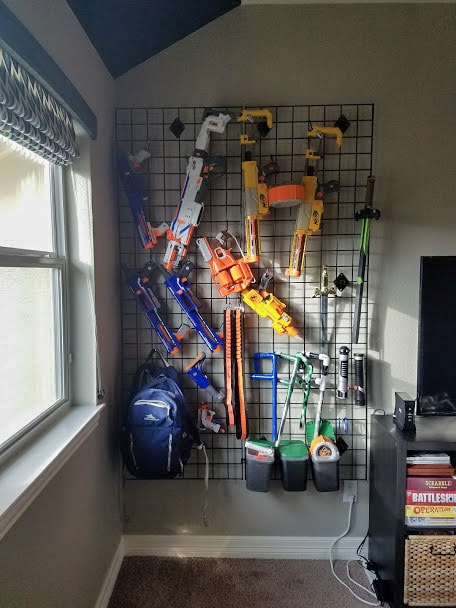 Nerf guns hanging on grid wall